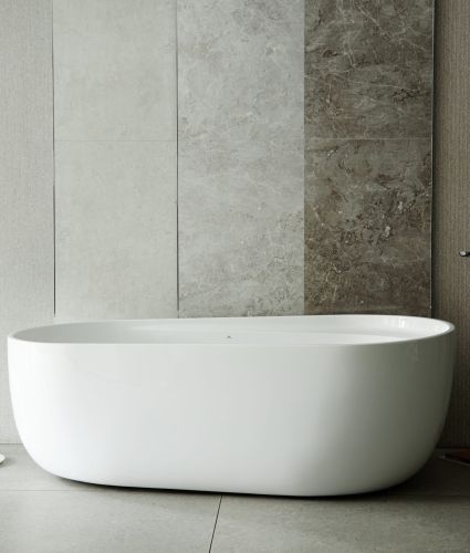 Moderna vasca da bagno indipendente davanti a pannelli in pietra testurizzata con rubinetto a pavimento e portasciugamani, interno del bagno vuoto che enfatizza il design pulito e minimalista.